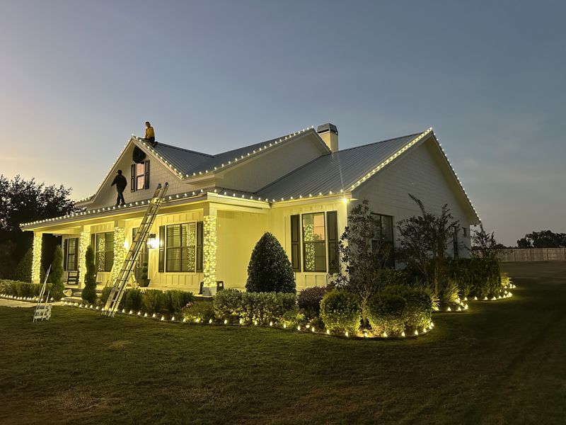 Home with gables and dormers outlined in warm white Christmas lights