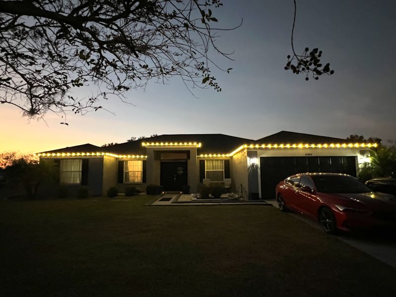 Florida home with roofline Christmas lights against a sunset sky